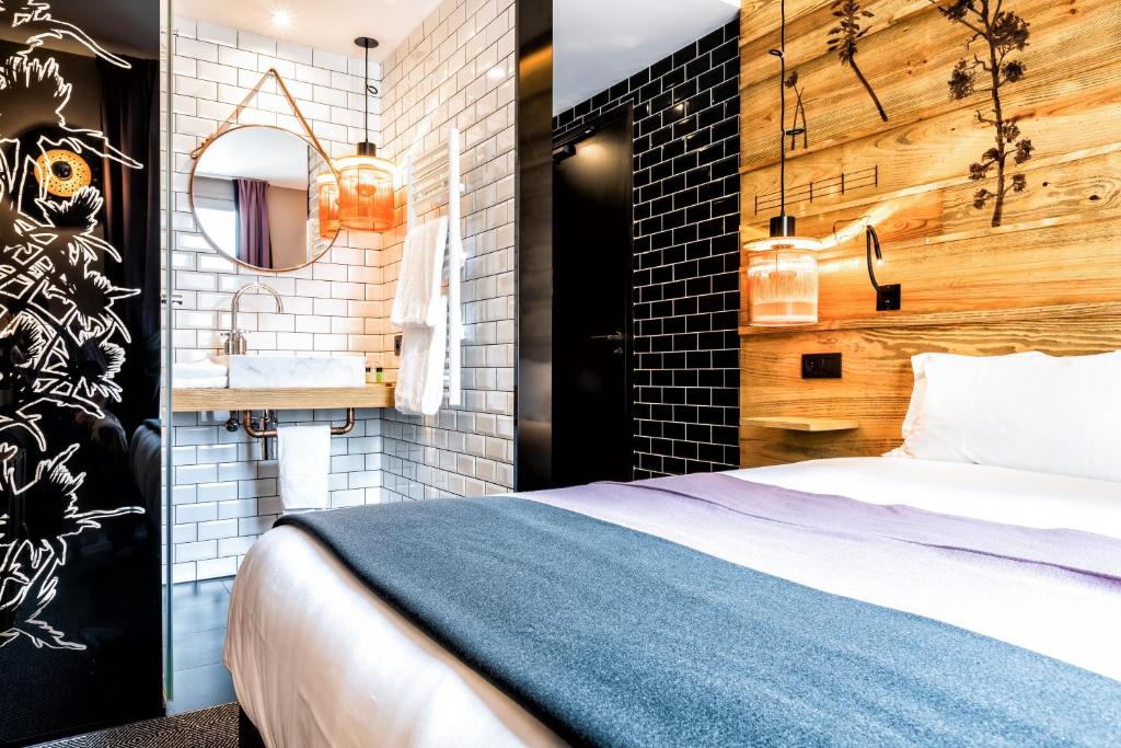 a bedroom with a bed and a bathroom with a sink at Hotel Restaurant Au Boeuf Couronné in Paris