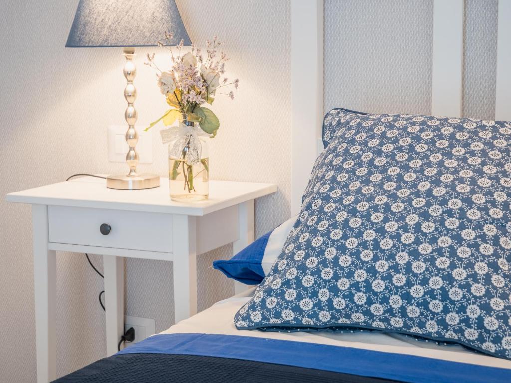 a bed with a blue pillow and a table with a lamp at Podere n°8 Agriturismo in Maremma in Alberese