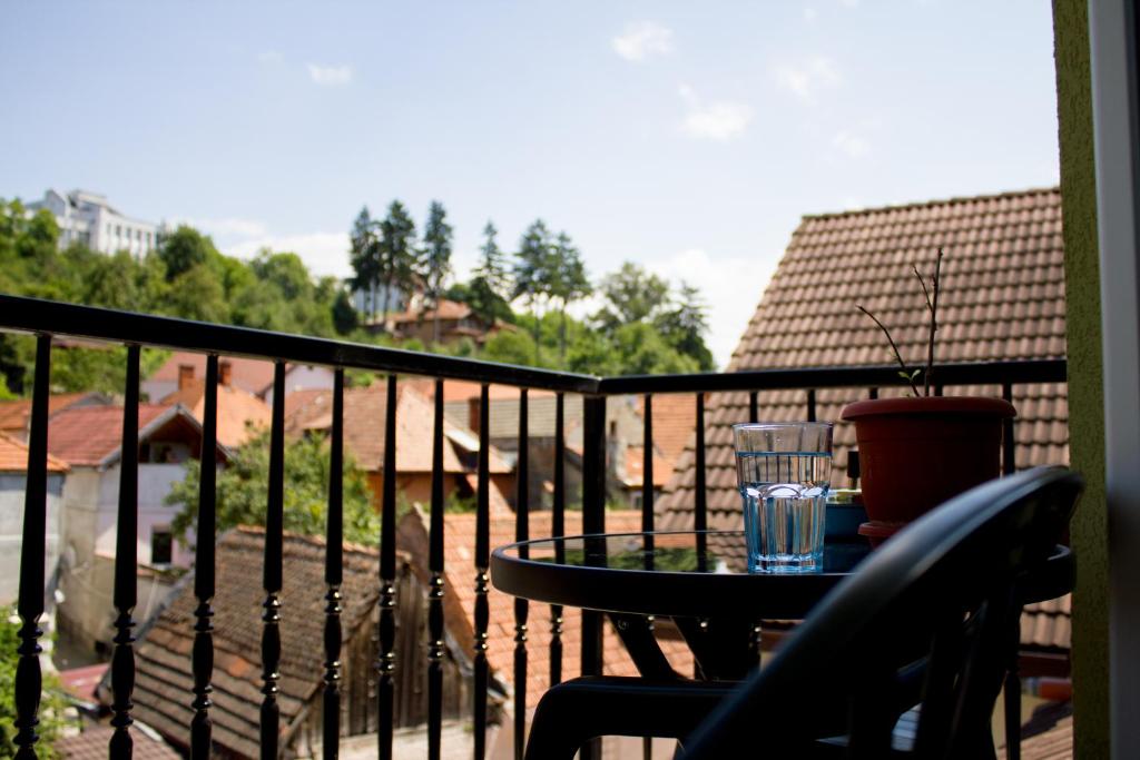 a balcony with a table with a glass on it at Avram Iancu Private Apartment in Braşov