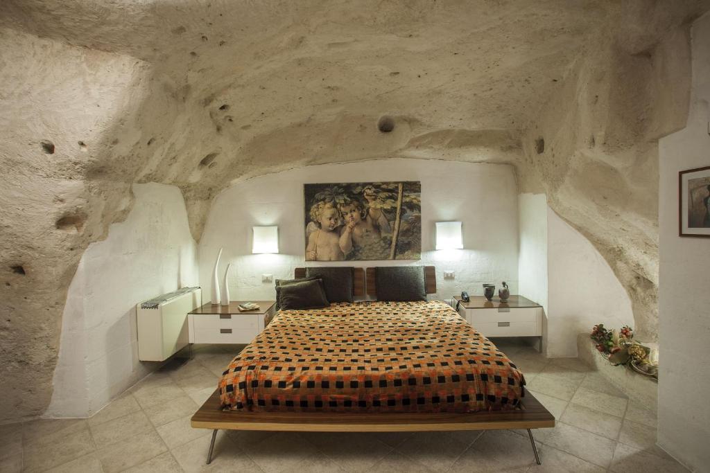 
a room with a bed and a painting on the wall at Residence San Pietro Barisano in Matera
