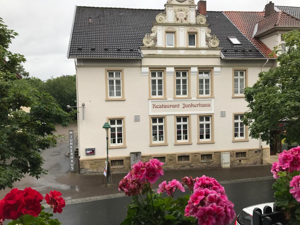 un edificio con flores rosas delante de él en Hotel Junkerhaus, en Bad Salzuflen
