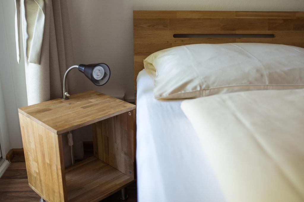 
a bedroom with a bed and a lamp at FT Hotel & Restaurant in Freiburg im Breisgau
