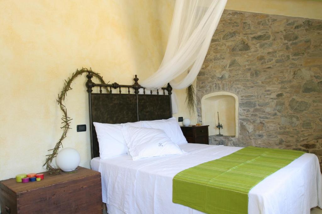 a bedroom with a bed and a stone wall at I Freschi in San Bartolomeo al Mare