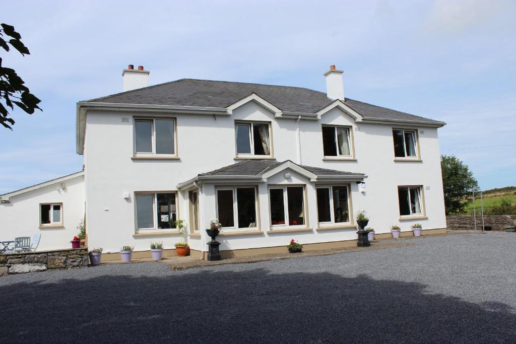 una grande casa bianca con molte finestre di St. Catherines a Doolin