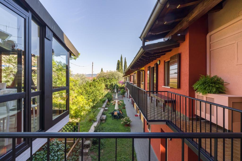 an apartment balcony with a view of a garden at Ca' dei Gatti in Toscolano Maderno