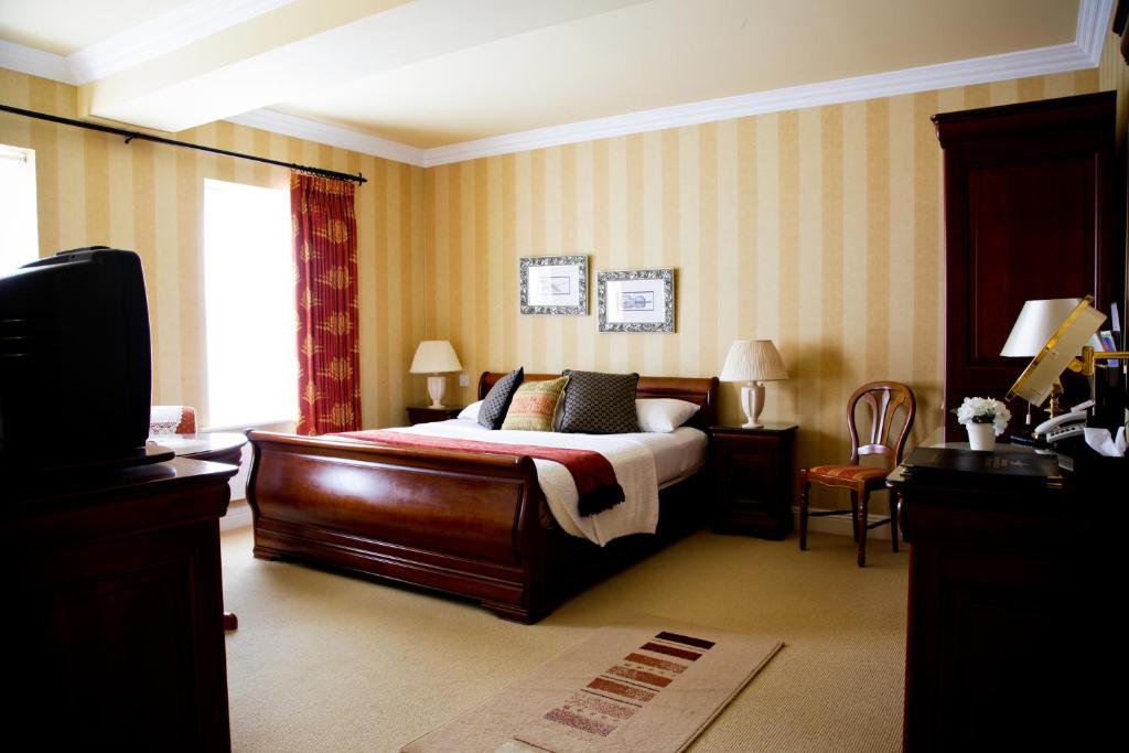 a bedroom with a bed and a tv in it at Ardmore Country House in Westport