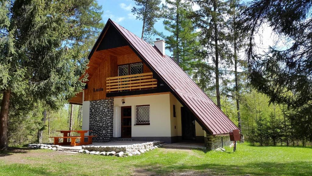 a small cabin with a red roof in the woods at Chata Lucia in Stará Lesná