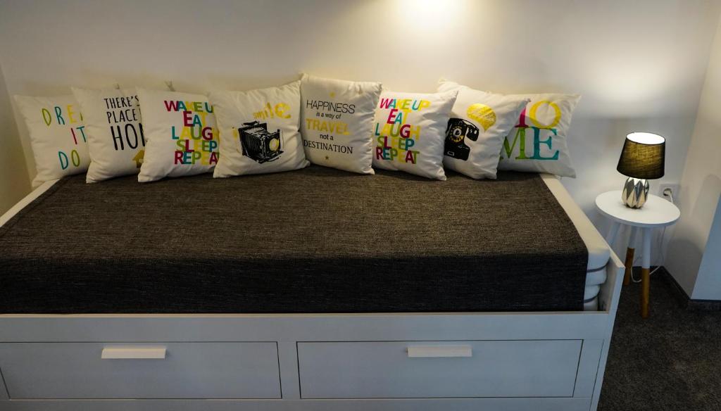 a bed with a bunch of pillows on it at DownTown DeLuxe Apartment in Eger