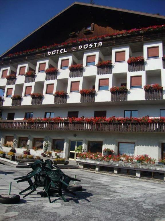 un edificio con una estatua delante en Albergo Posta, en Colle Santa Lucia