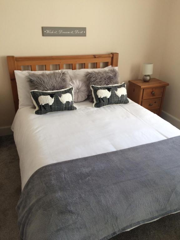 a bedroom with a large bed with two pillows at Edgehill B&B in Kirkhill of Kennethmont