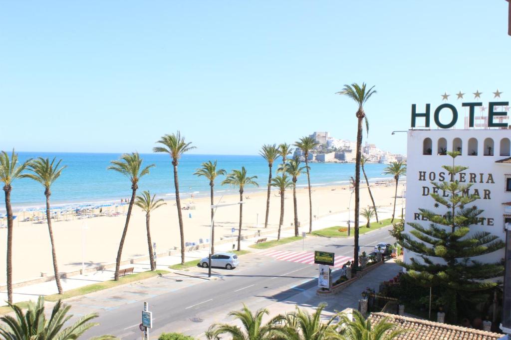 ペニスコラにあるApartamento En Primera Linea De Playaのヤシの木と海のビーチにあるホテル