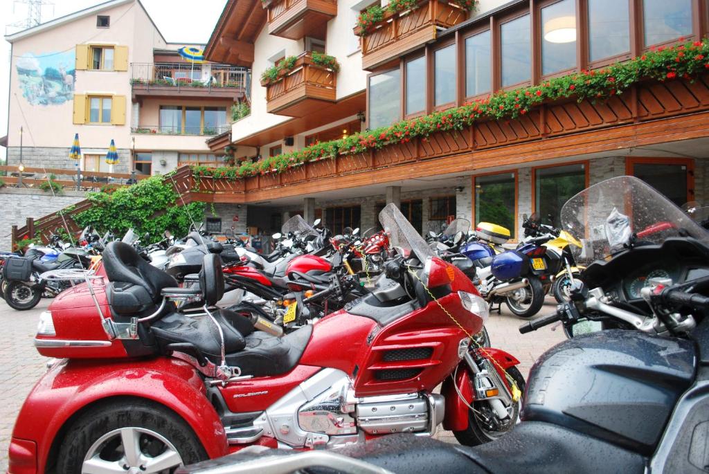 eine Gruppe von Motorrädern, die vor einem Gebäude geparkt sind in der Unterkunft Alps Oriental Wellness HOTEL in Campodolcino