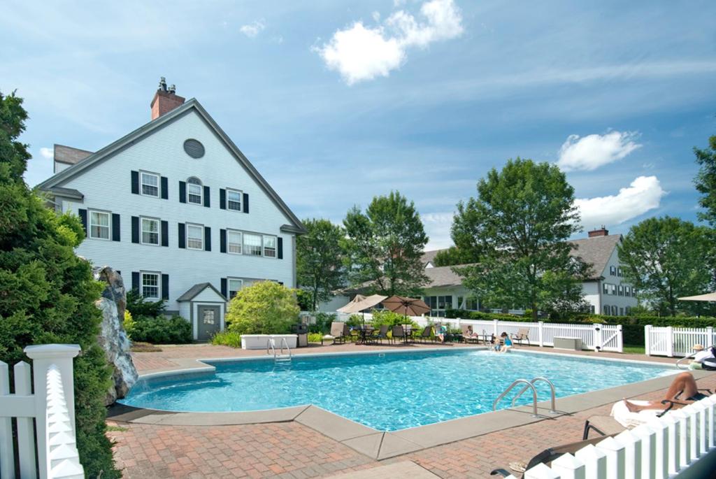 a white house with a blue and white swimming pool at The Essex Resort in Burlington