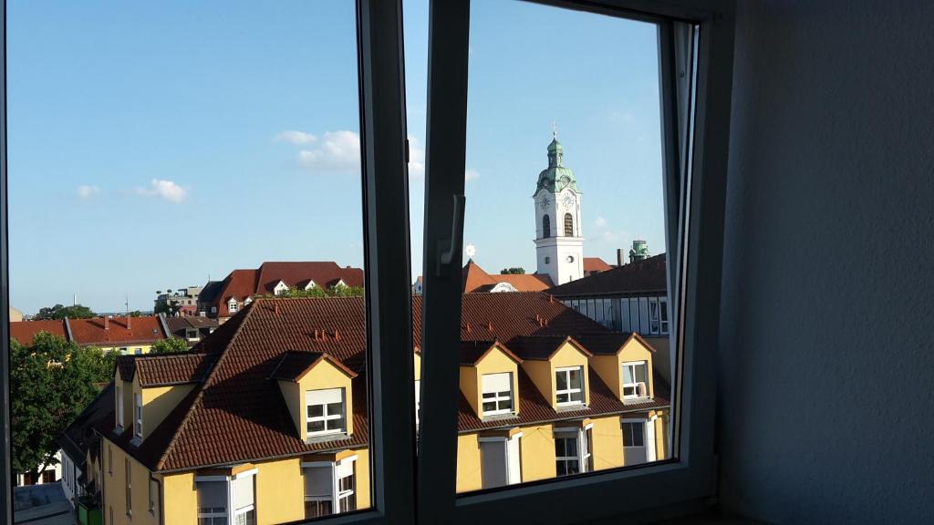 una ventana con vistas a un edificio con una torre de reloj en Schwalbennest, en Fürth