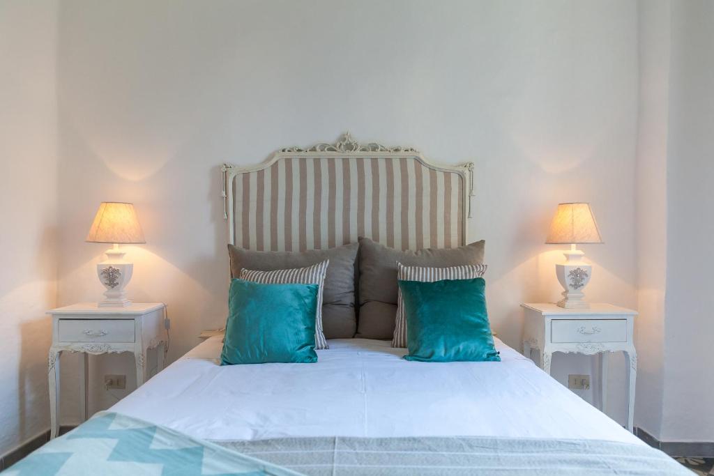 - une chambre avec un lit doté d'oreillers bleus et de 2 lampes dans l'établissement Dimore del Faso, à Fasano