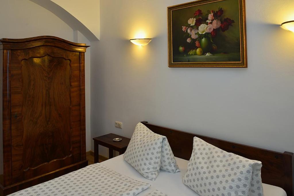 ein Schlafzimmer mit einem Bett und einem Bild von Blumen an der Wand in der Unterkunft Várfal Vendégház in Fertőrákos