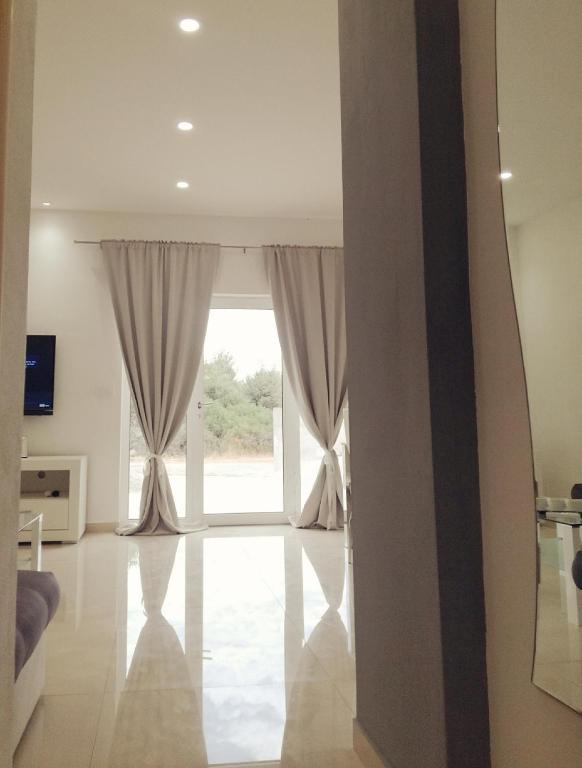a living room with a large window with curtains at Ivana Šibenik in Šibenik