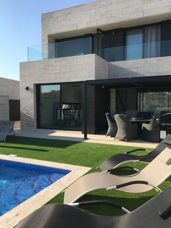 uma casa moderna com uma piscina e um pátio em Villa Mar menor Golf em Torre-Pacheco