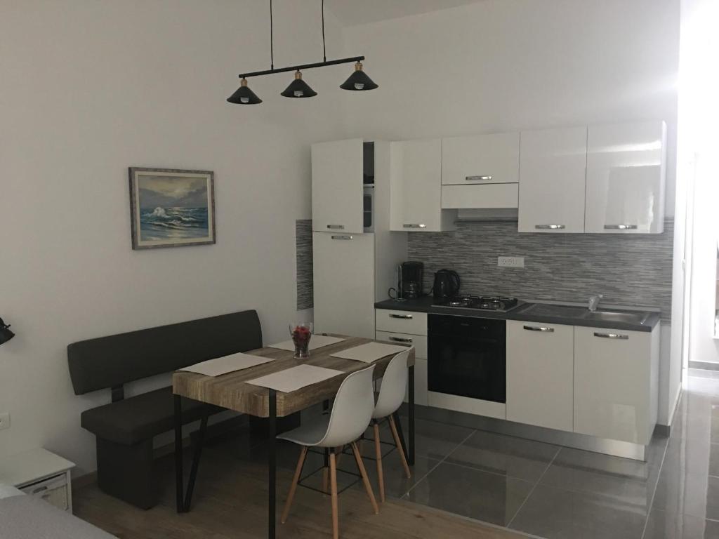 a kitchen with a table and a dining room at Studio apartman Dado in Bale