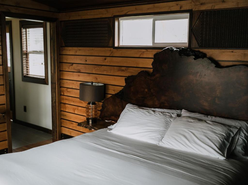 a bedroom with a large bed with a wooden wall at Pitchwood Inn in Raymond
