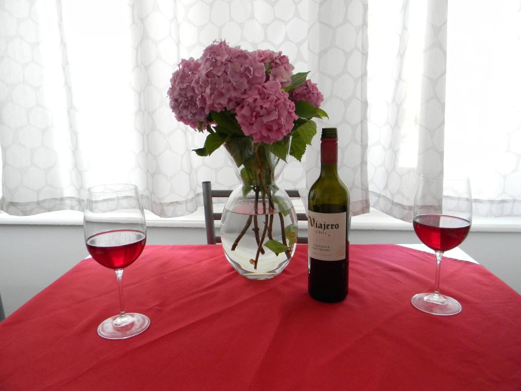 un tavolo con una bottiglia di vino e un vaso di fiori di Feel at home studio apartment a Matulji (Mattuglie)