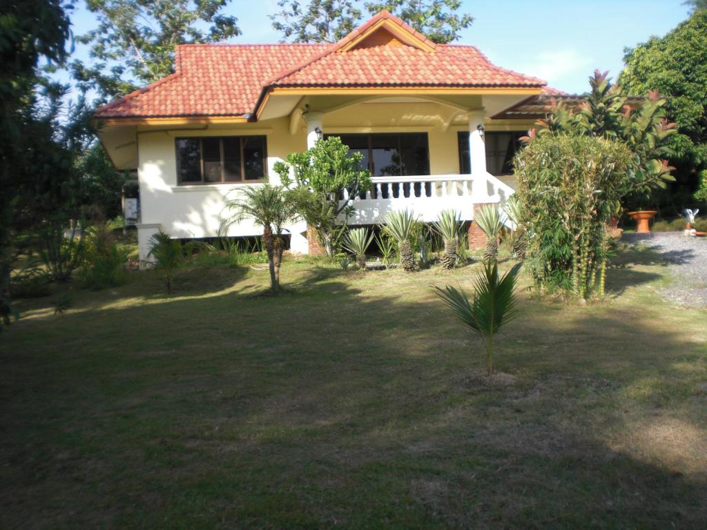 ein kleines gelbes Haus mit rotem Dach in der Unterkunft House of Garden in Chiang Rai