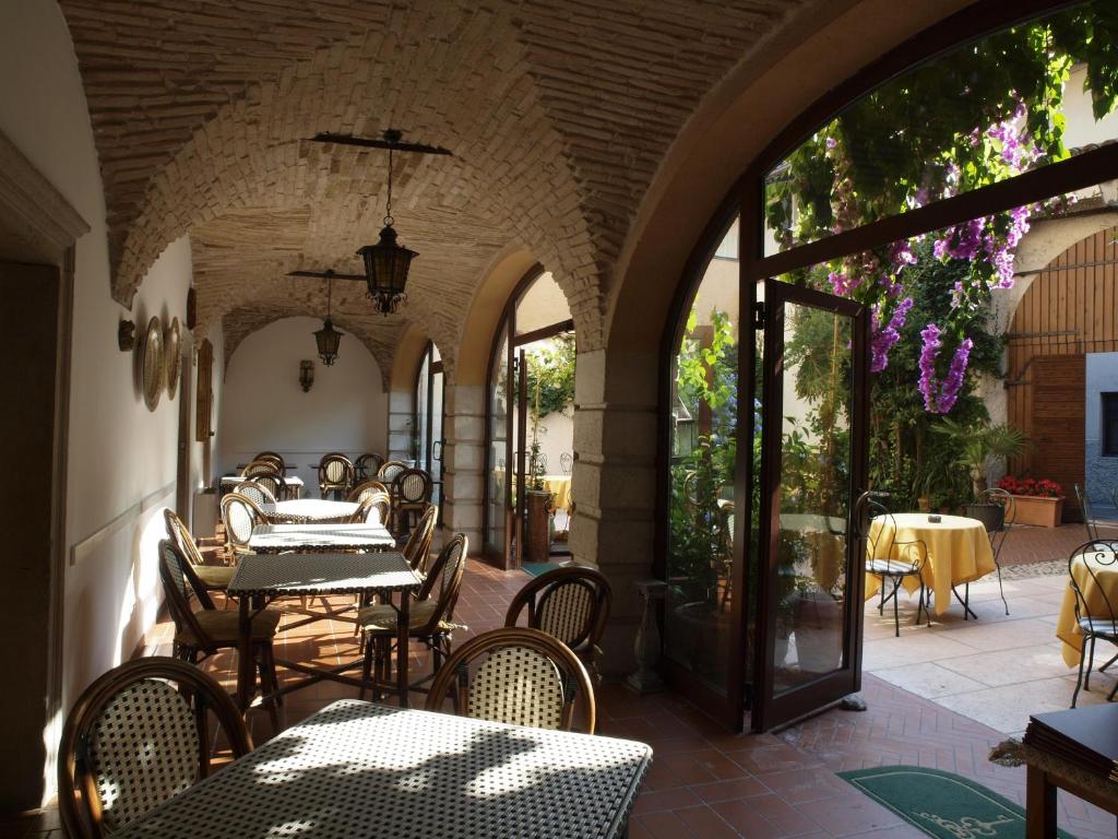 un patio esterno con tavoli e sedie in un edificio di Hotel San Filis a San Felice del Benaco
