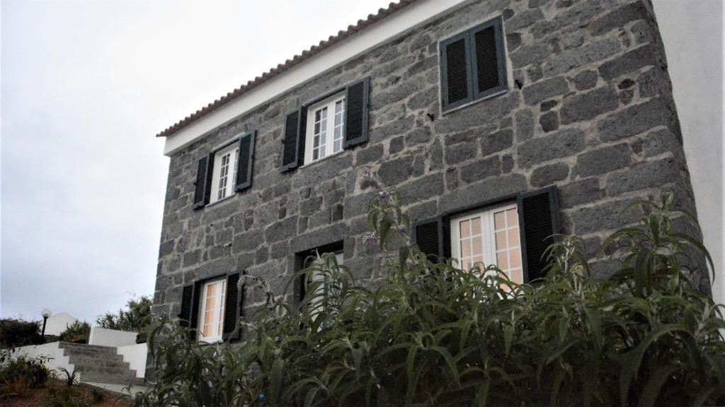 a stone building with windows on the side of it at BELO CAMPO - Ilha do Faial (Horta) in Castelo Branco