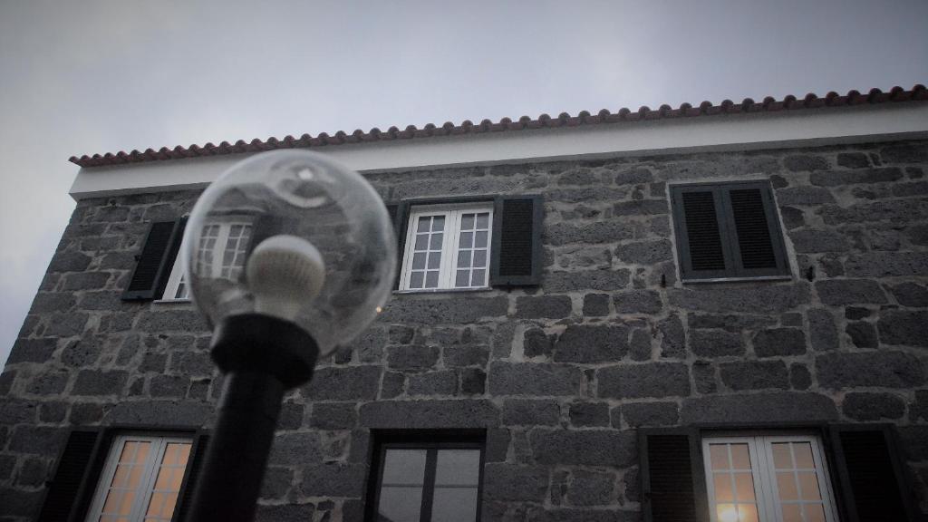 a street light in front of a brick building at BELO CAMPO - Ilha do Faial (Horta) in Castelo Branco