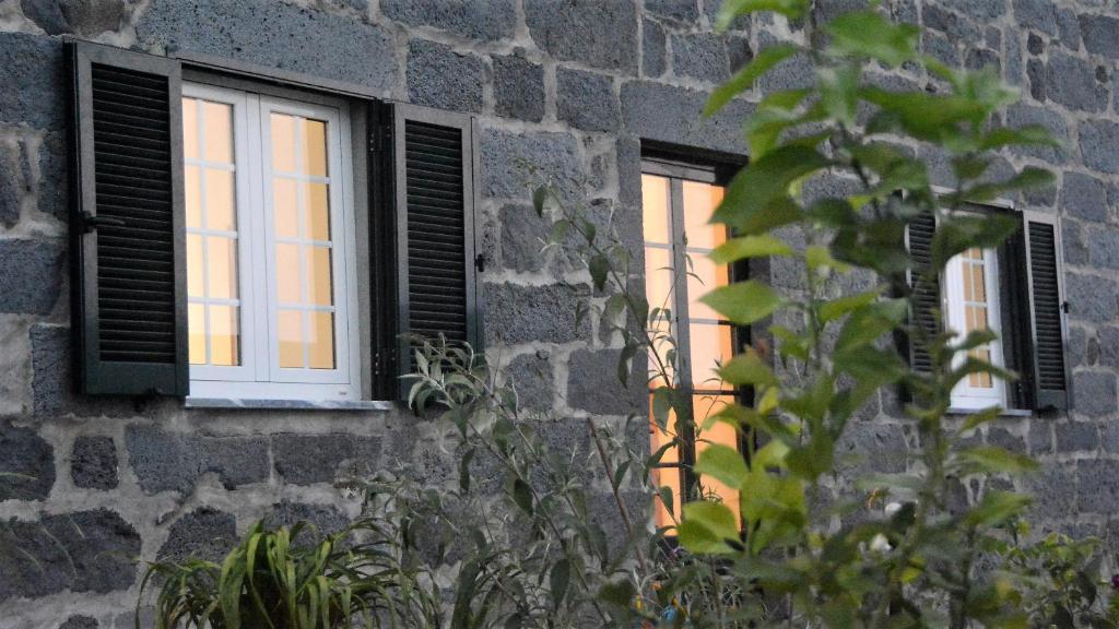 two windows in a stone building with the sunlight coming in at BELO CAMPO - Ilha do Faial (Horta) in Castelo Branco