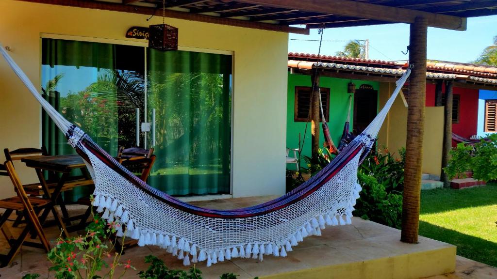 a hammock outside of a house at Pousada Área Talismã in São Miguel do Gostoso