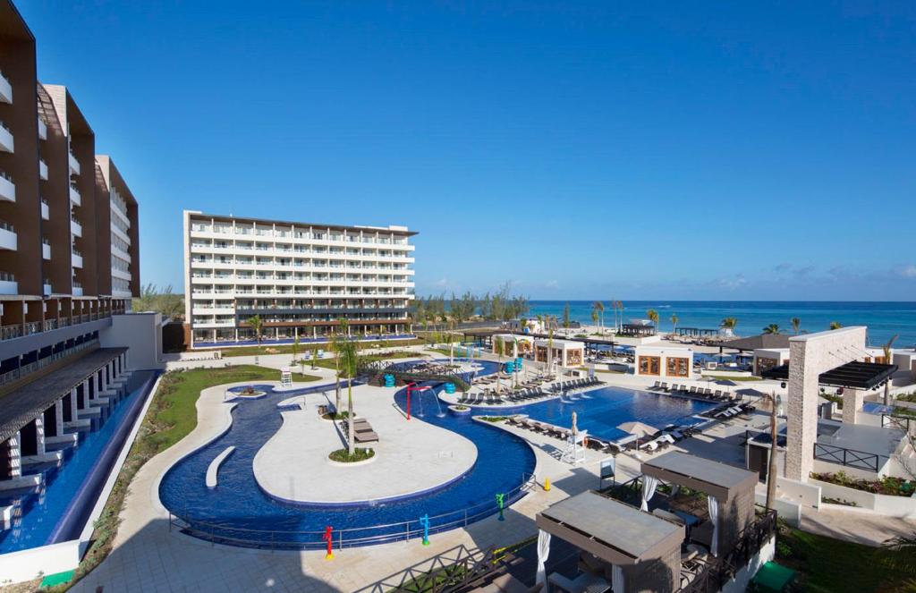 een uitzicht op een resort met een zwembad en de oceaan bij Royalton Blue Waters Montego Bay, An Autograph Collection All-Inclusive Resort in Falmouth