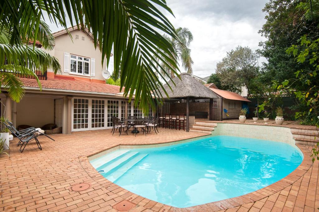 una gran piscina azul frente a una casa en The Brother's Guest House en Durban