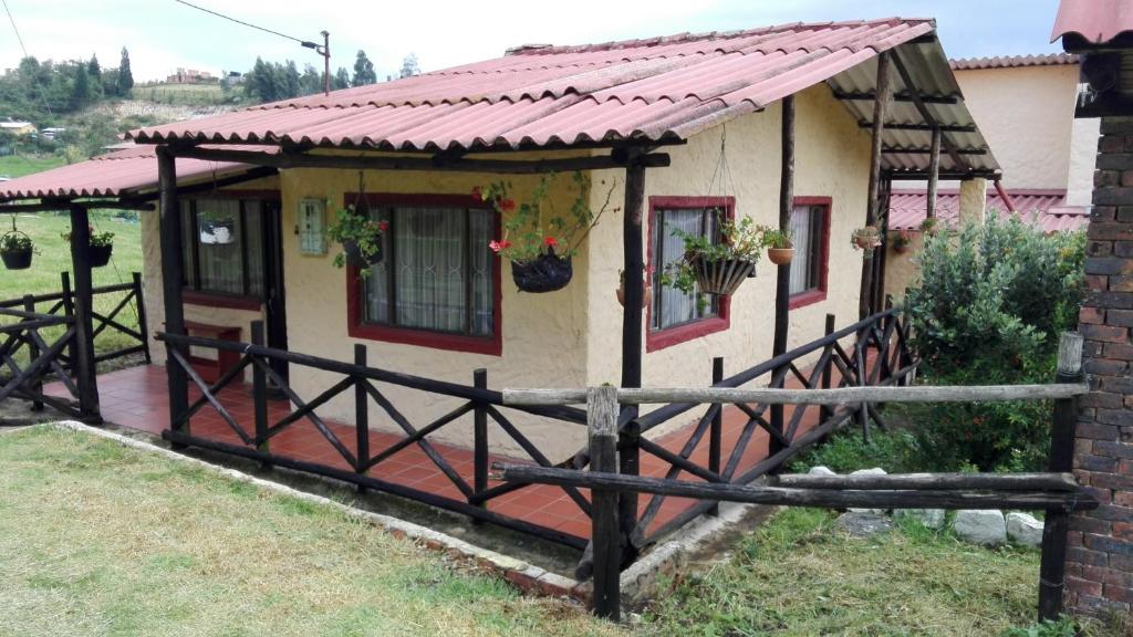 una pequeña casa con techo rojo en Cabaña La Esperanza, en Paipa