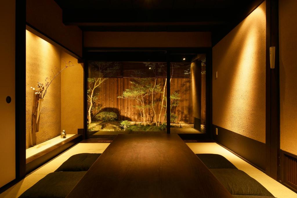um quarto com um longo banco em frente a uma janela em Kuraya Nanseicho em Quioto