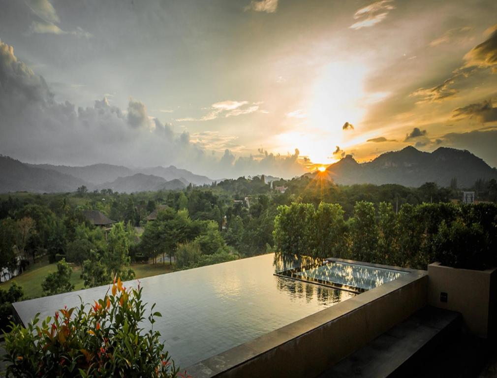 - une vue sur un lac avec le coucher du soleil en arrière-plan dans l'établissement 2 Bedroom Luxury Pool Penthouse at ATTA, à Pak Chong