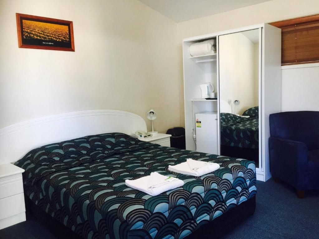 a hotel room with a bed and a mirror at Springsure Overlander Motel in Springsure