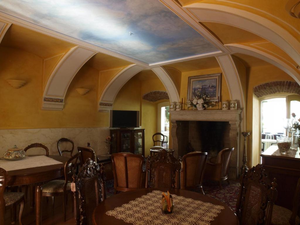 una sala da pranzo con camino, tavolo e sedie di Hotel San Filis a San Felice del Benaco