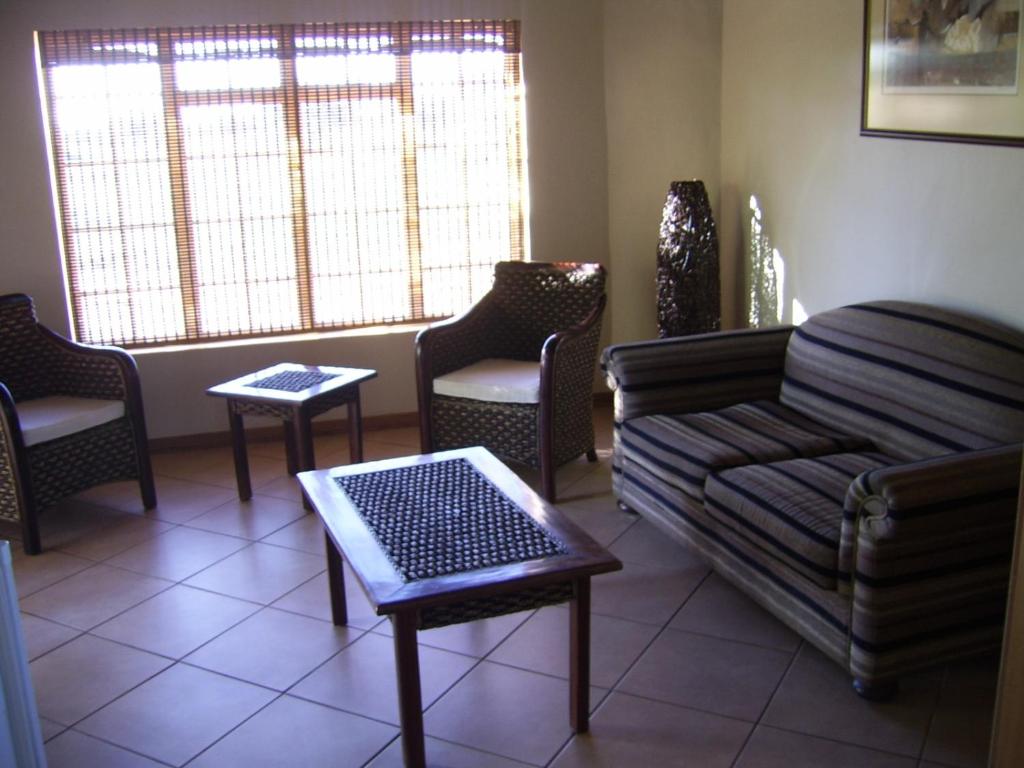 - un salon avec un canapé, des chaises et une fenêtre dans l'établissement Dronfield Reserve, à Kimberley