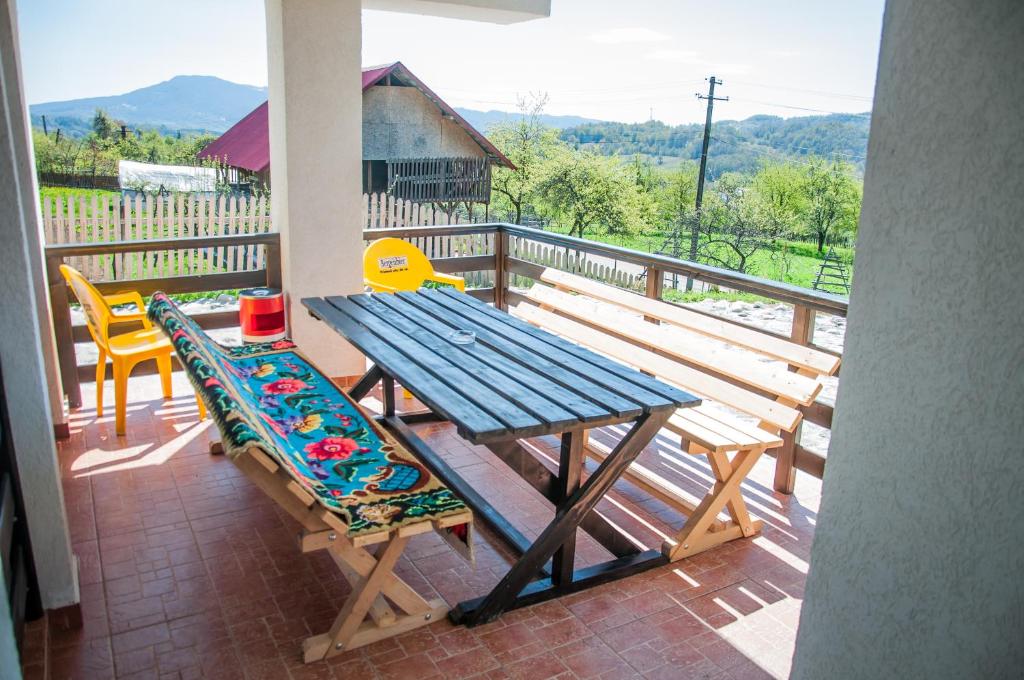 una mesa de picnic y 2 sillas en un porche en Pensiunea Drumul Voievozilor, en Arefu