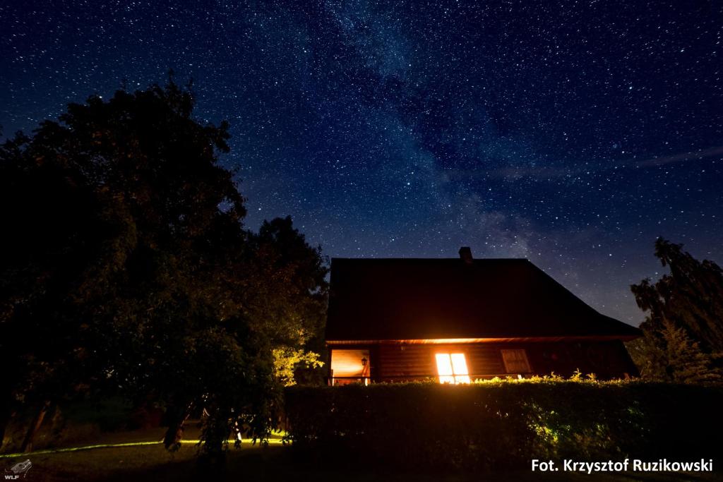 eine Hütte in der Nacht mit Sternenhimmel in der Unterkunft Dom w Czostkowie na Suwalszczyźnie in Rospuda