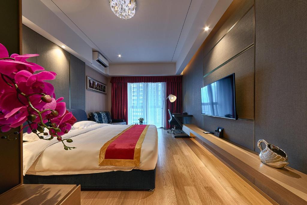 a hotel room with a bed and a flat screen tv at Heefun International Apartment - Zhujiang New Town FuLi Brand New World Plaza in Guangzhou