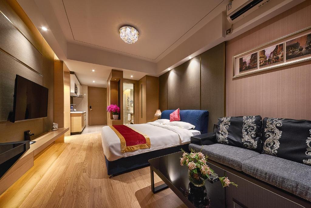a hotel room with a bed and a couch at Heefun International Apartment - Zhujiang New Town FuLi Brand New World Plaza in Guangzhou