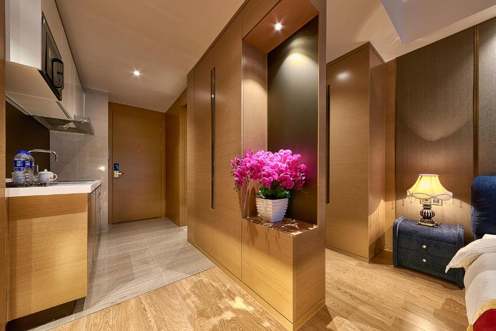 a bedroom with a vase of flowers on a counter at Heefun International Apartment - Zhujiang New Town FuLi Brand New World Plaza in Guangzhou