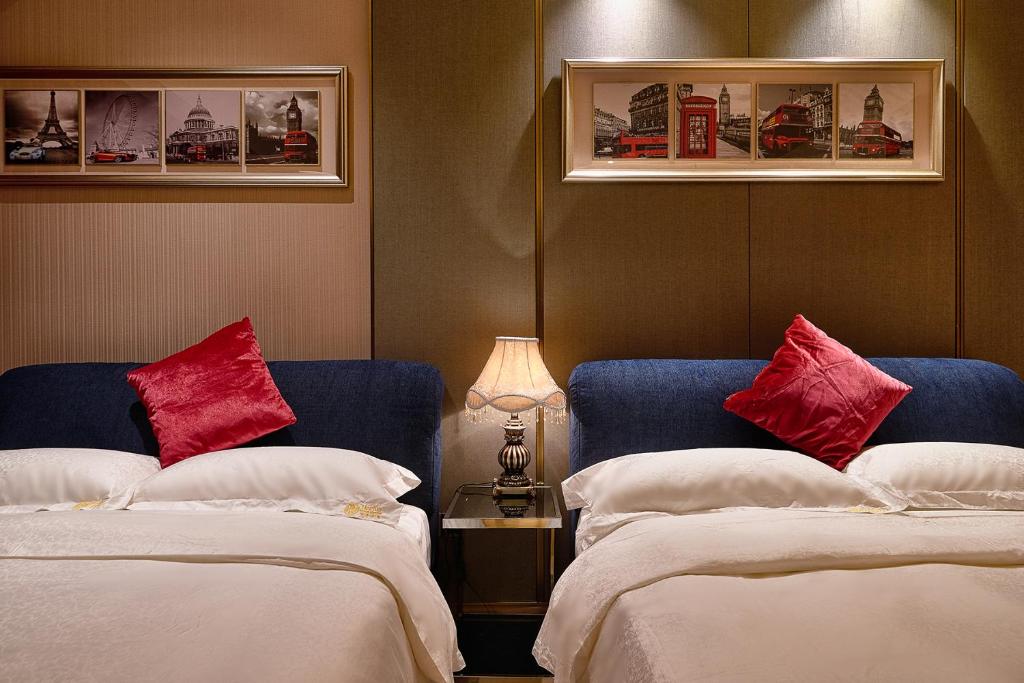 a hotel room with two beds with red pillows at Heefun International Apartment - Zhujiang New Town FuLi Brand New World Plaza in Guangzhou