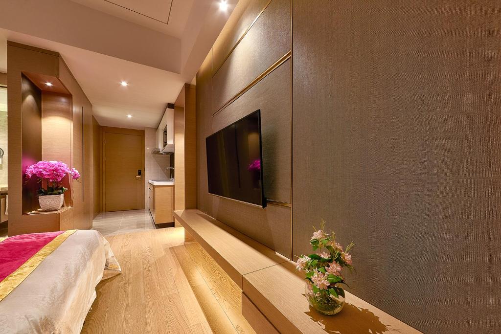 a bedroom with a flat screen tv on a wall at Heefun International Apartment - Zhujiang New Town FuLi Brand New World Plaza in Guangzhou