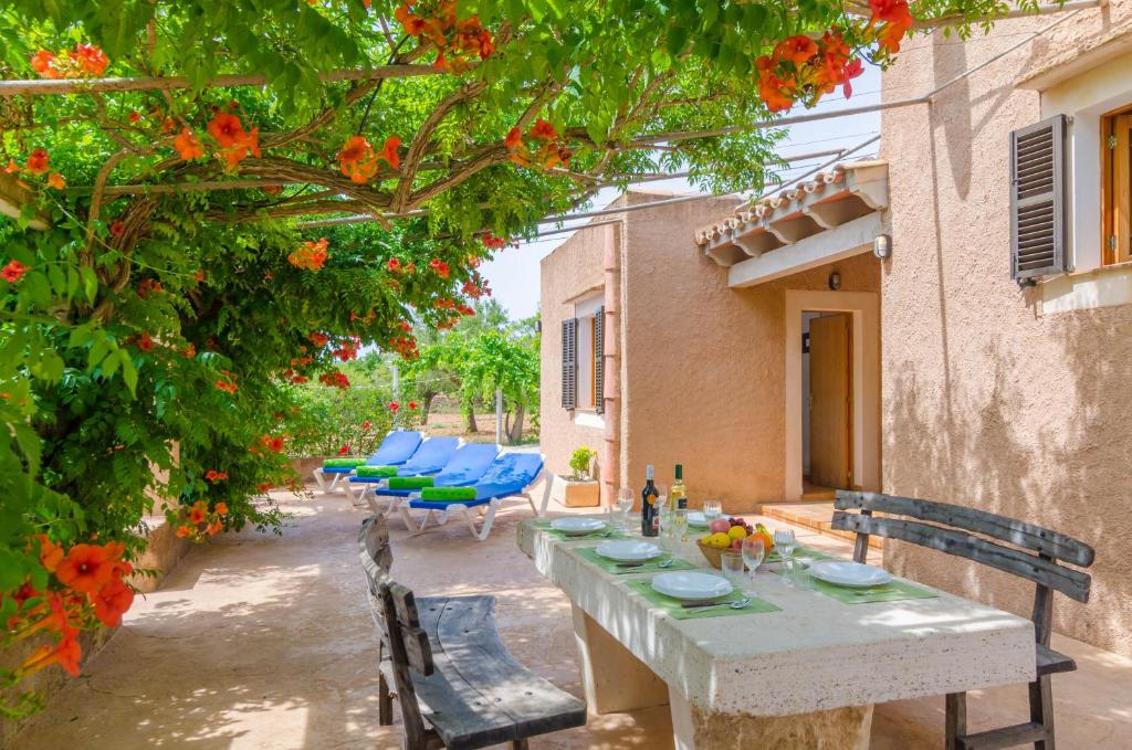 einen Tisch und Stühle in einem Garten mit Blumen in der Unterkunft Cas General in Portopetro