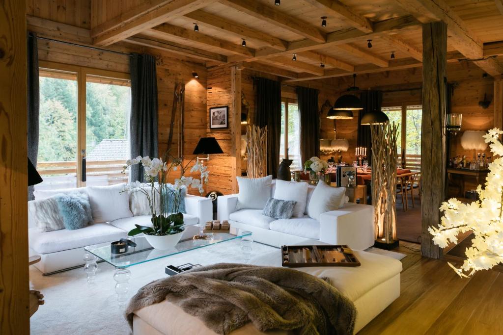 a living room with white couches and a table at La FERME des Lombardes in Saint-Jean-de-Sixt