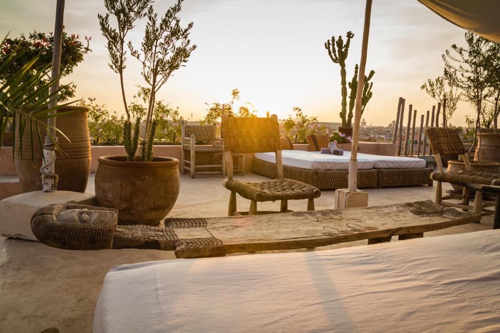 - une terrasse avec 2 lits et des plantes en pot dans l'établissement Riad 144, à Marrakech
