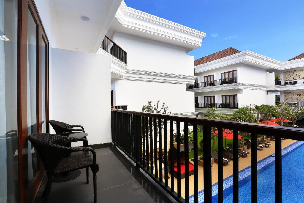 a balcony of a building with two chairs at Grand Palace Hotel Sanur - Bali in Sanur